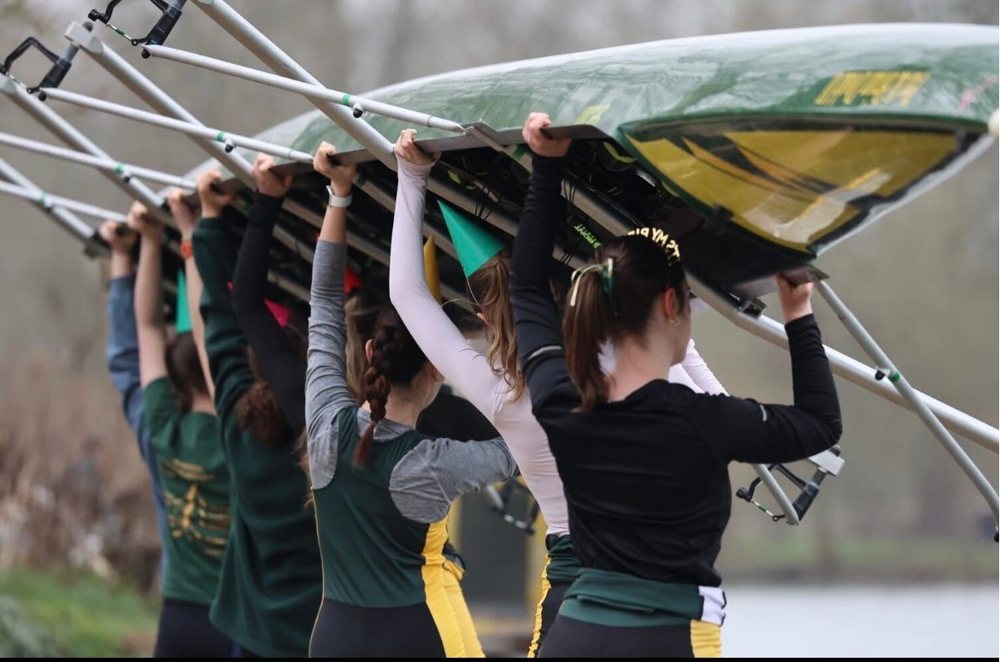 Rowers carrying a boat overhead at the river