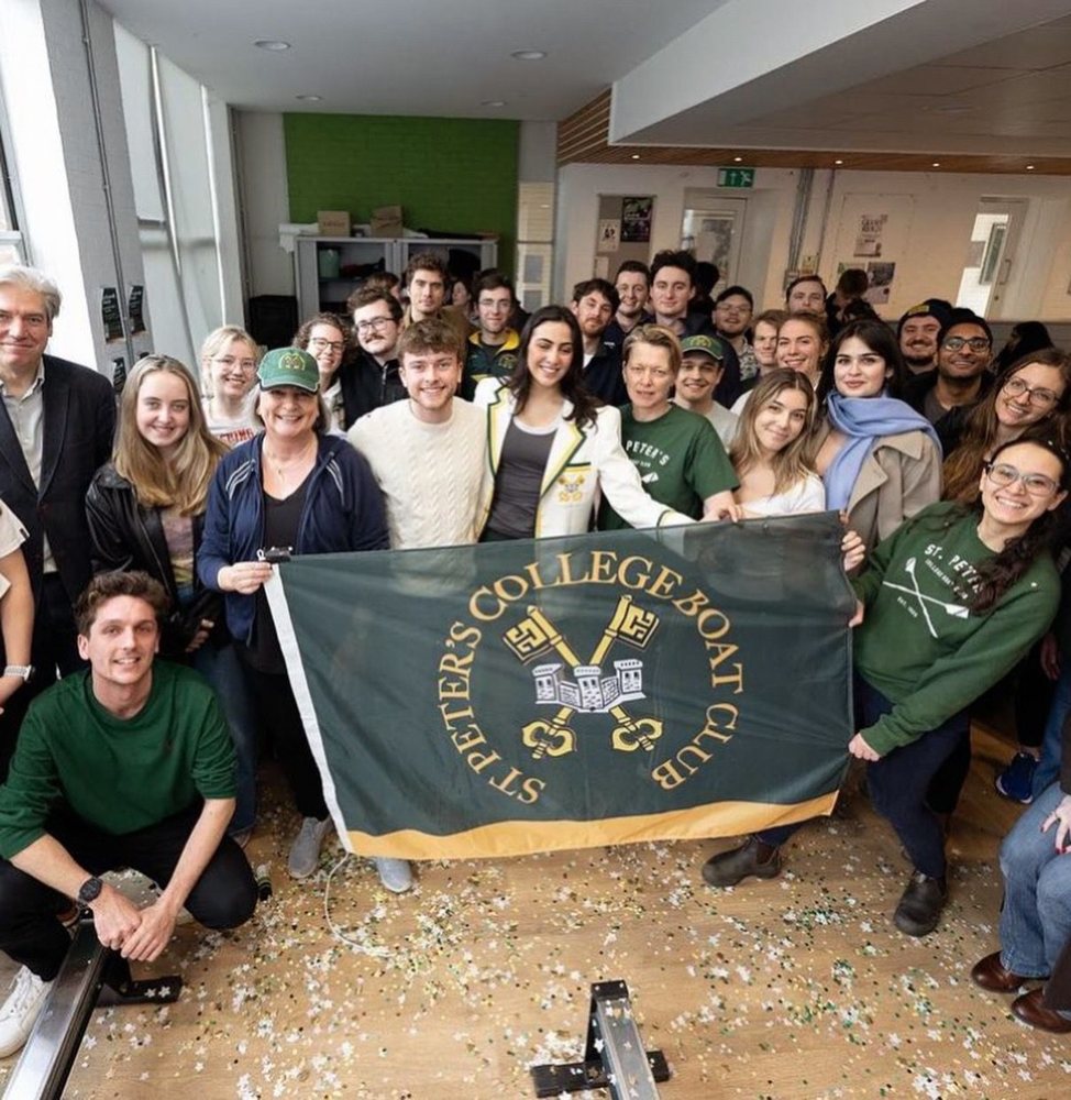 Club members celebrating with the St Peter's College Boat Club flag